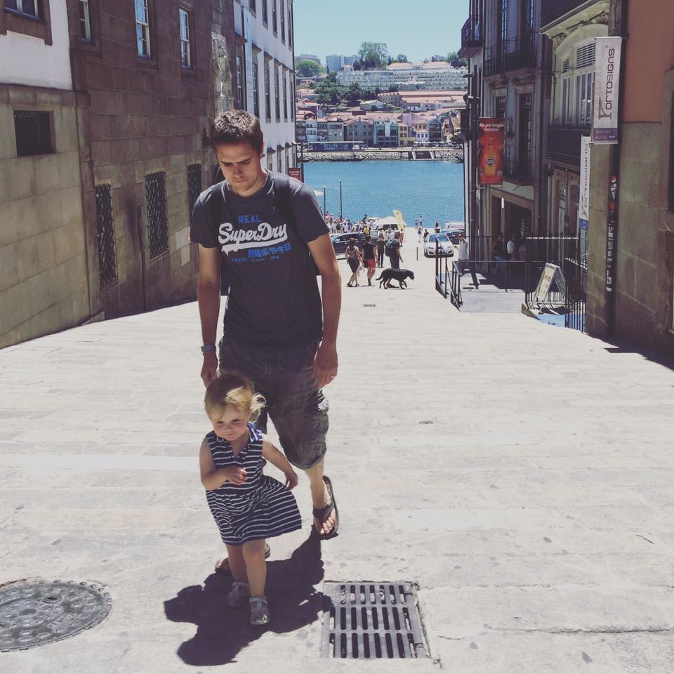 father and daughter walking up a steep hill in the old town of porto