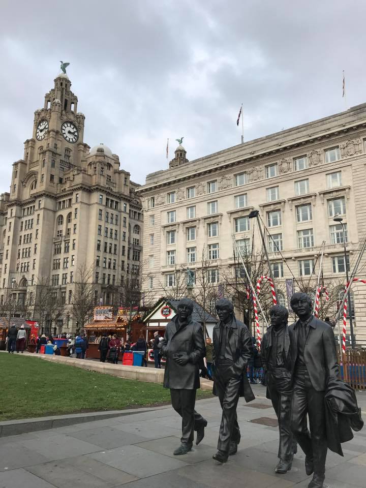 The iconic statues of the Beatles, with the Liver bird building in the background