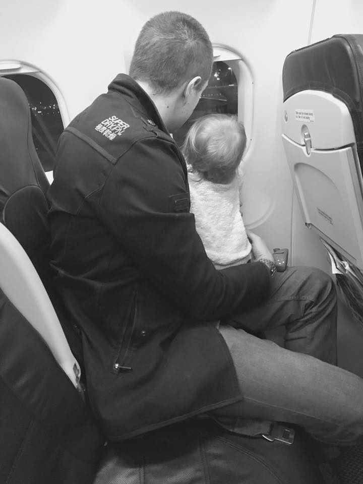 Dad looking out of plane window with Daughter