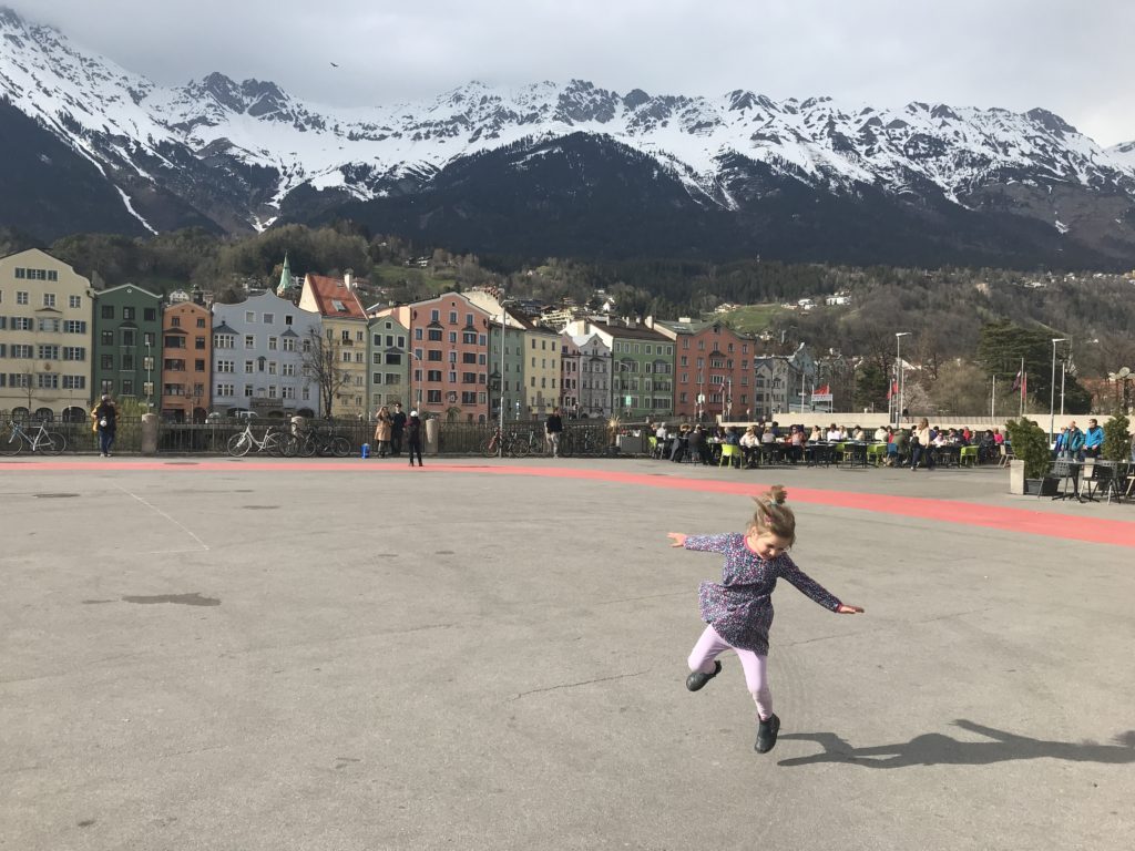 Child dancing in front of Innsbruck houses