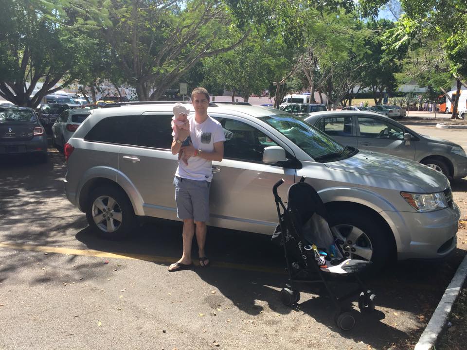 dad with baby in front of car in mexico