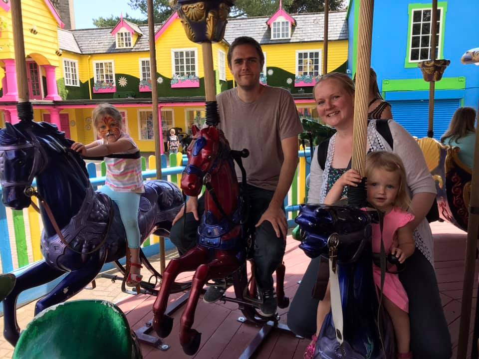 mum dad and daughters on carousel during weekend trip to Alton Towers