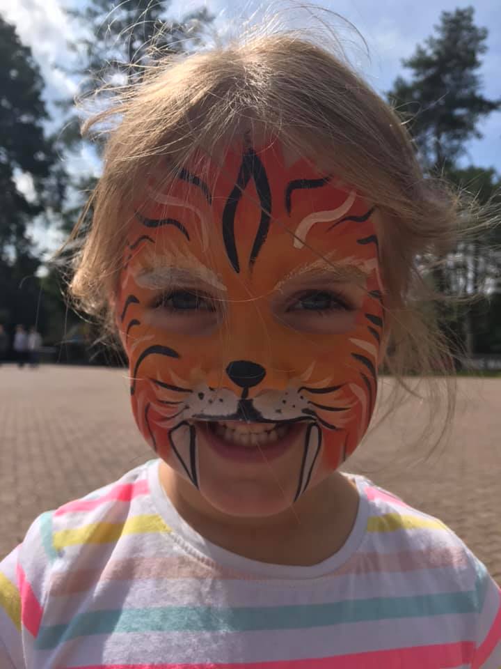 girl with face painted as a tiger