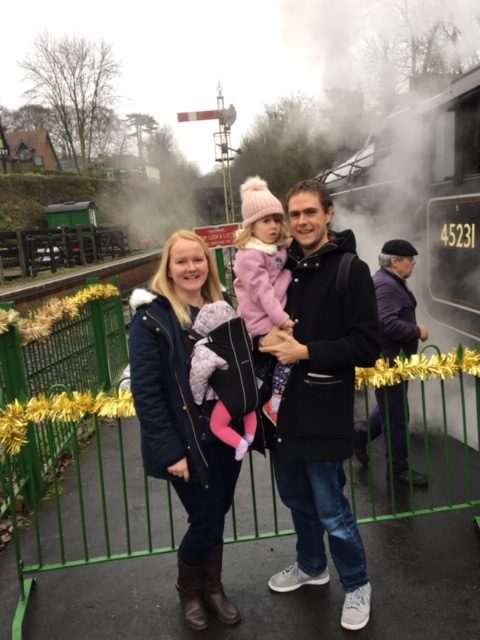 Mum dad and two girls in front of steam train 