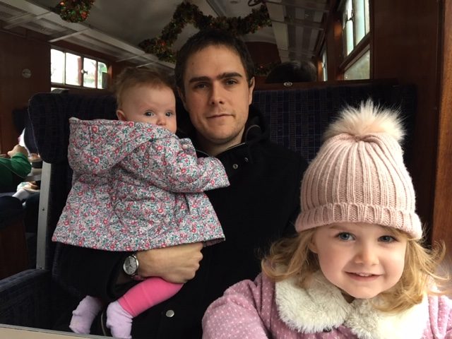 dad and two girls on train