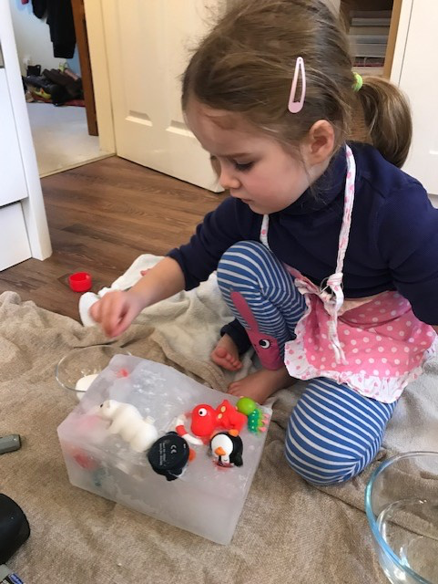 child hitting block of ice 