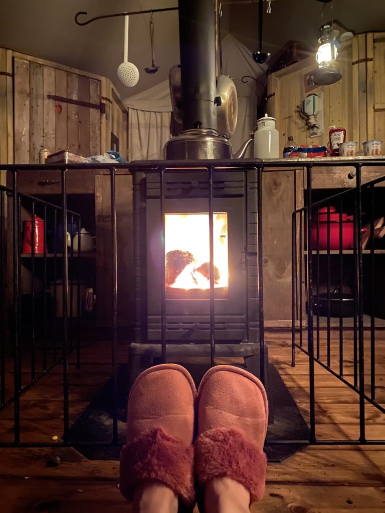 slippers in front of fire in a glamping tent 