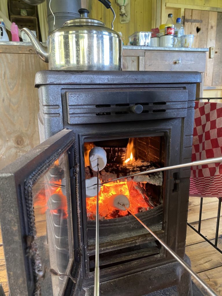 toasting marshmallows in a fire at Glamping tent 