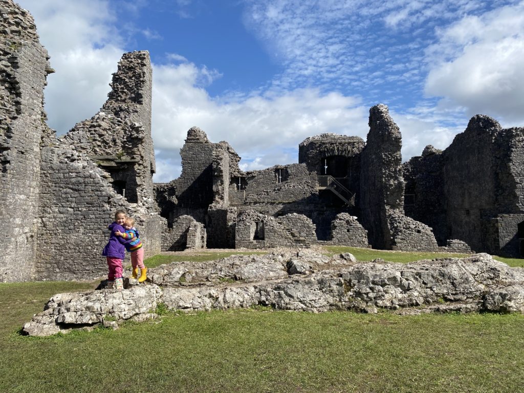 girls hugging in castle ruins TRAVEL REVIEW - Glamping at Cwmberach Uchaf Farm with Feather Down