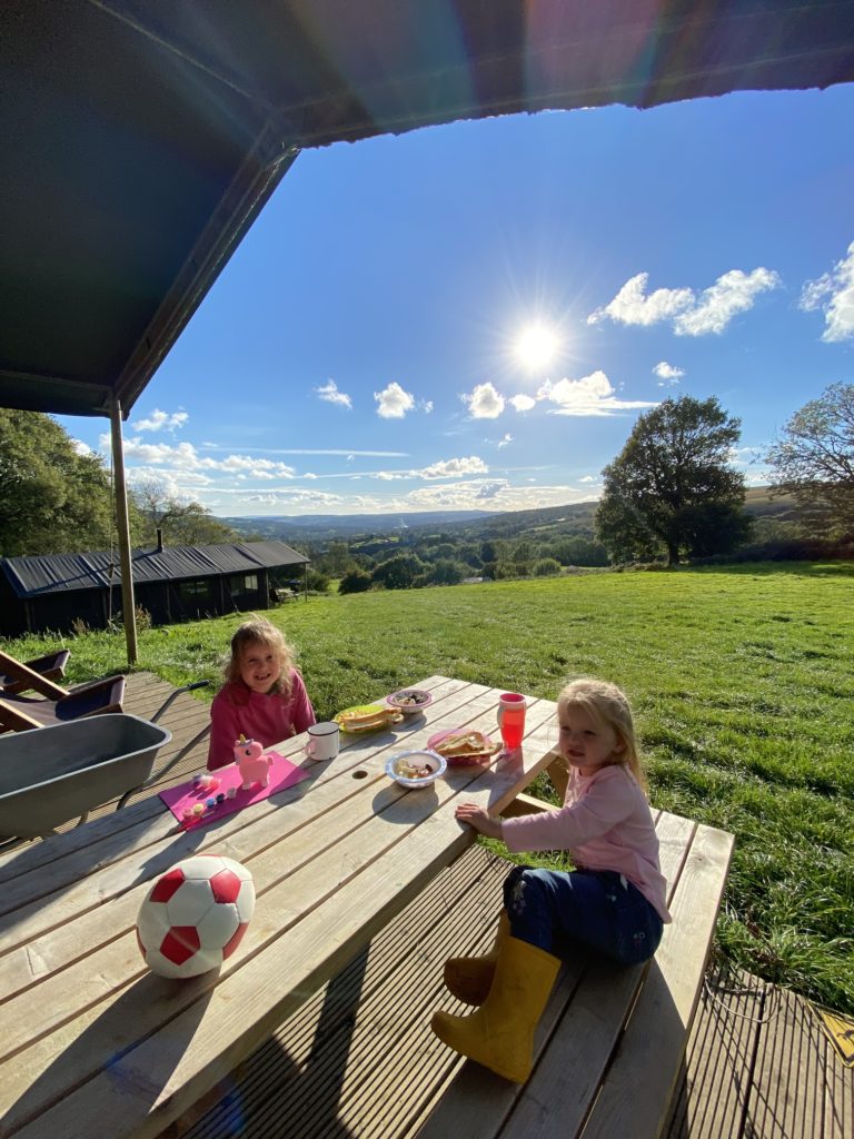 children eating food on picnic table at Glamping tent