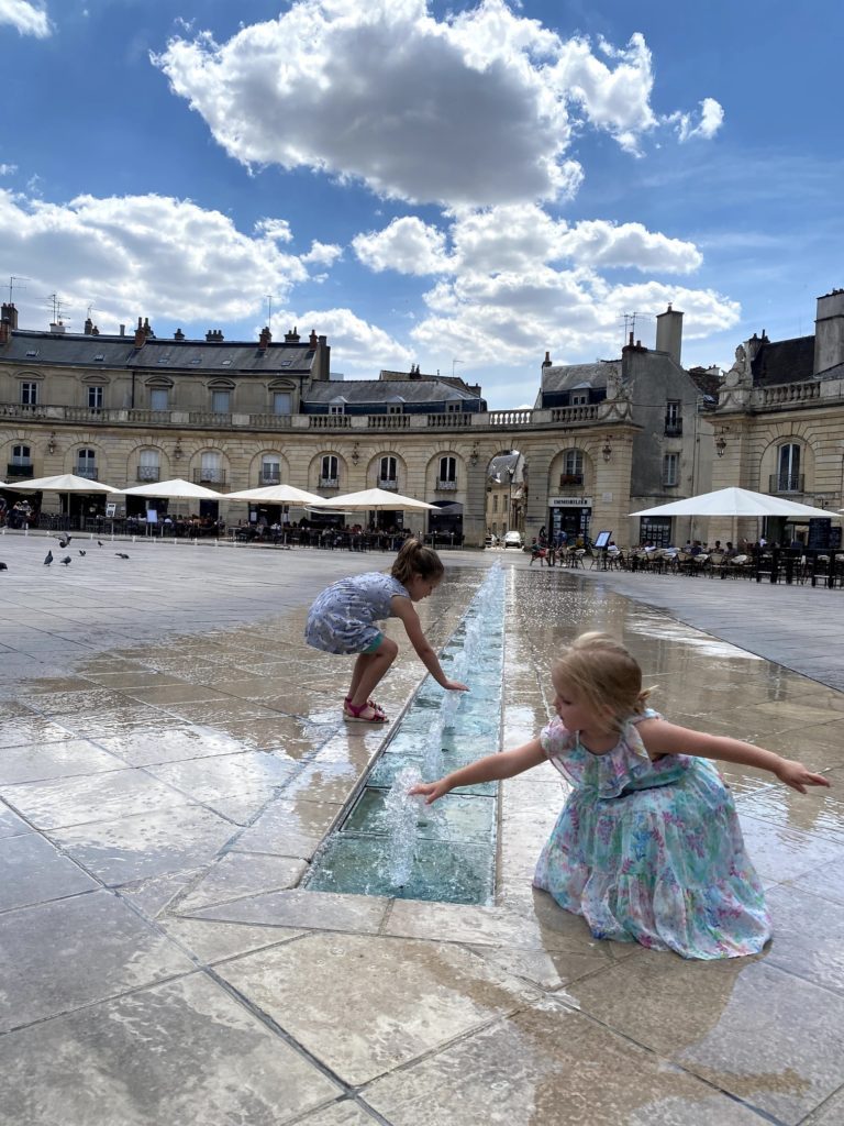 girls playing in fountain in dijon