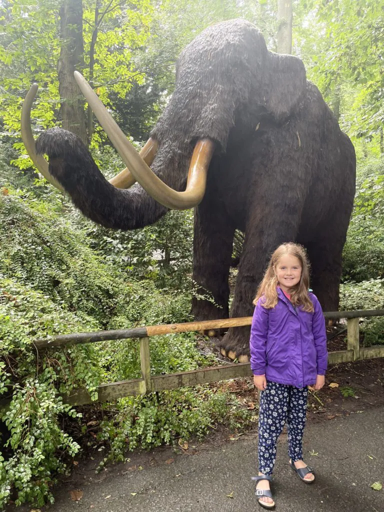 Girl in front of Wooley Mammoth statue at Howletts zoo