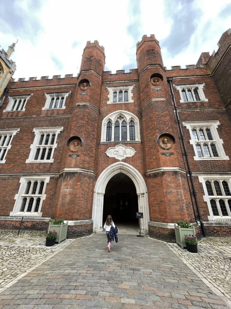 walking through the courtyard at hampton court palace. 